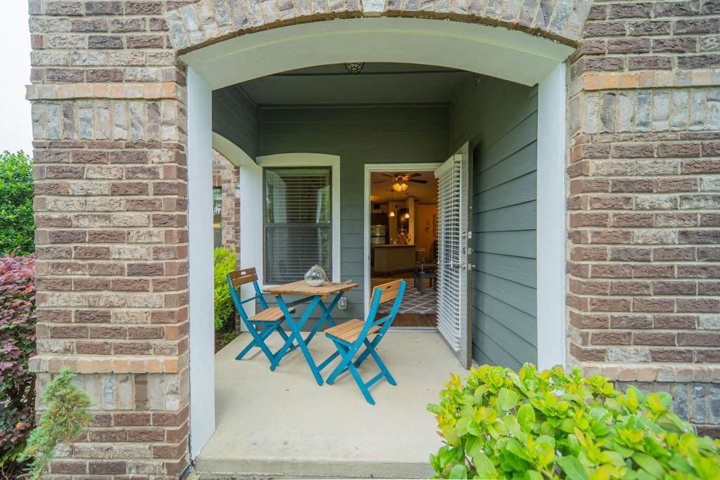 a patio with a table and chairs on a porch
